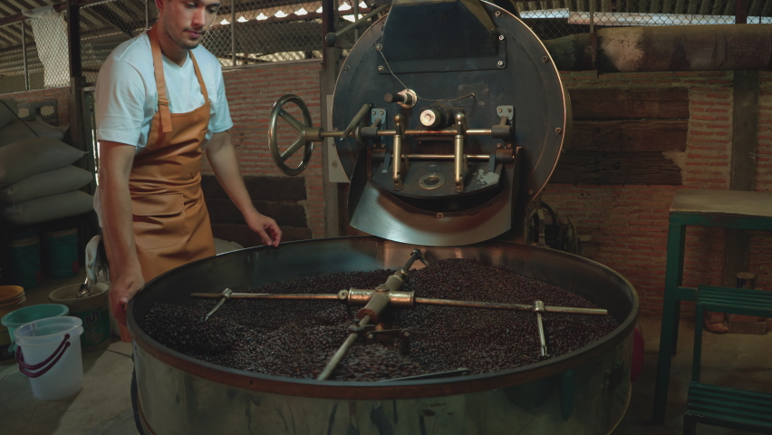 Men smell coffee beans and check the quality from roasting machines. Young Man half-Asian-caucasian 29 years old working in a coffee factory. Small business owner, coffee roaster, industrial Royalty-Free Stock Footage #1088422613