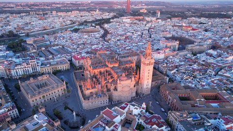 Seville cathedral at sunrise, flying around the famous gothic cathedral in Seville, Spain in the morning, aerial view of Seville city skyline and gothic cathedral, European travel destination. 