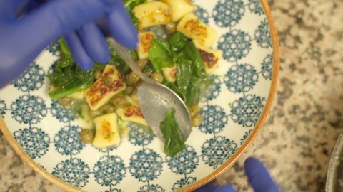 fried gnocchi with spinach in plates with blue ornaments, italian dish, 4k video, close-up view, top view