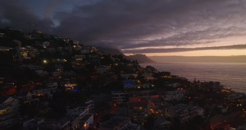 Breath taking elevated footage of residential borough at dusk. Luxurious residences in slope falling to sea coast. Cape Town, South Africa