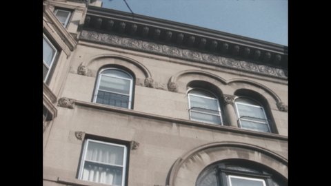 1960s: Italianate building, arched windows, elaborate decorative carving. Boy stands on stoop, bounces ball, turns, looks, leans on railing, smiles, walks down steps.
