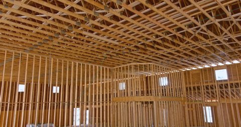 Unfinished roofing wooden frame house construction with roof beams, trusses, timber, braces framing an interior view house building