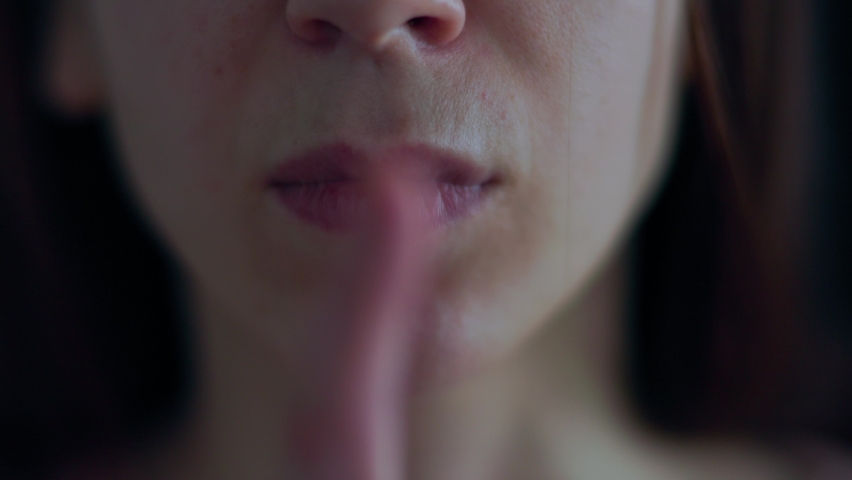 close up of a caucasian woman portrait doing silence gesture with finger. Censorship concept, Secret information. on a black background Royalty-Free Stock Footage #1088437203