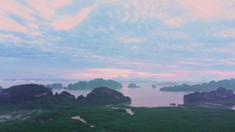 Aerial view of Phang Nga bay with mountains at sunrise in Krabi, Thailand. Landscape of Amazing red sky with dramatic sea at magic moment in the morning. Fantastic natural Drone shot over the Bay.