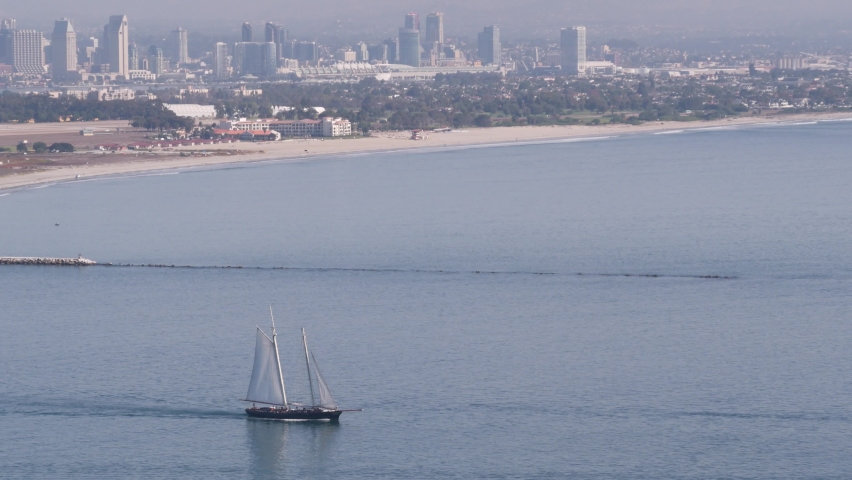 San Diego city skyline, cityscape of downtown with highrise skyscrapers, California coast, USA. View of Coronado island from above, Point Loma vista viewpoint. Frigate sail-powered ship, windjammer.
