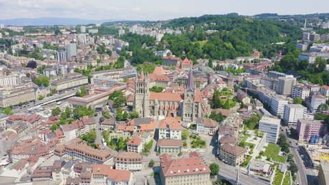 Inscription on video. Lausanne, Switzerland. Cathedral of Lausanne. La Cite is a district historical centre. Appears from the sand, Aerial View, Departure of the camera