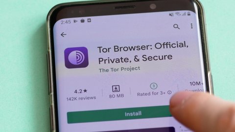 Tor browser application is installed on the mobile device. On the screen of the smartphone, the logo of the Tor Browser program. Anonymity on the Internet concept. 10.03.2022. Warsaw, Poland