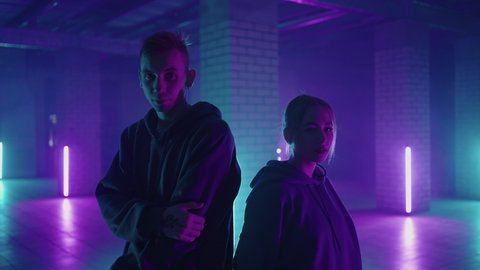 Professional Hip Hop break dancers . Stylish young couple dancing with real strobe lights . Against blue background of led lights. Dancing young couple in colourful neon studio light, hip hop dancers