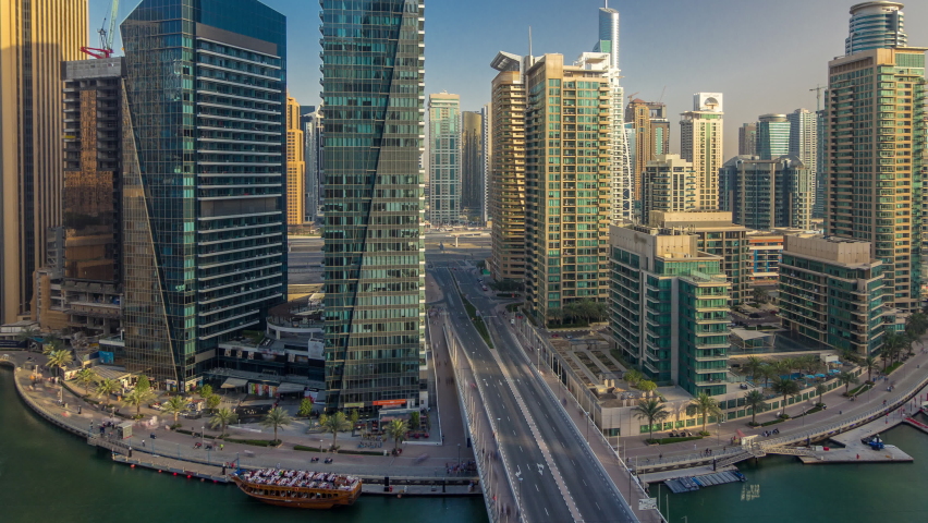 Amazing colorful dubai marina skyline during sunset timelapse. Great perspective of multiple tallest skyscrapers with traffic on the bridge. Sunlight over buildings. United Arab Emirates.