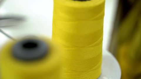 Closeup Shot Of Yellow Cotton Thread On A Spool In Sweatshop