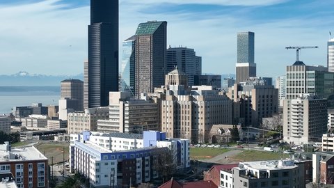 Cinematic 4K aerial drone footage of Harborview Medical Center on First Hill, Yesler Terrace, with Columbia Center Tower in the background downtown Seattle, Washington