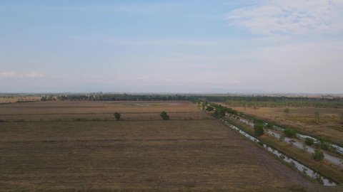 Aerial footage sliding to the left revealing Pak Pli and farmlands also grassland protected for migratory bird species from all over the world, Nakhon Nayok, Thailand.