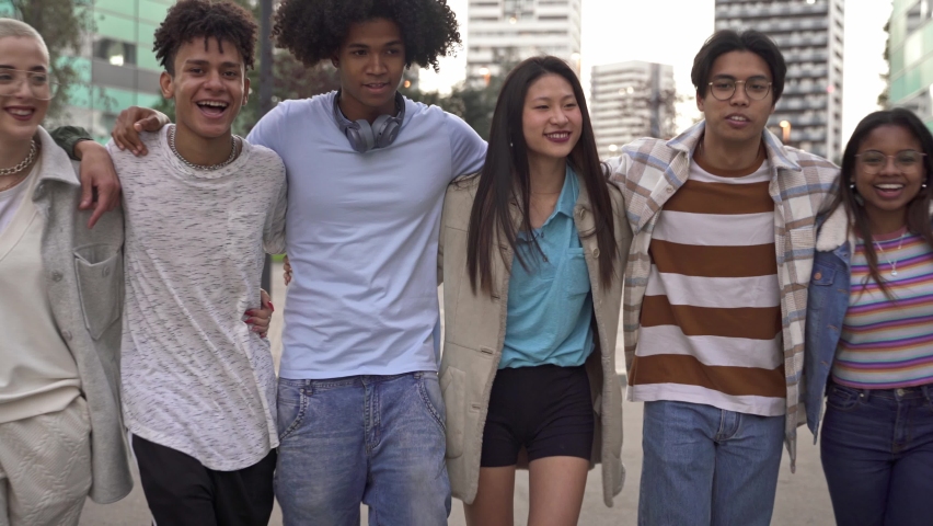 Group of multiracial carefree gen z friends embracing each other and walking together in the city. Youth diversity Royalty-Free Stock Footage #1088446719
