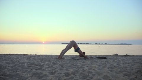 stretching outdoors. yoga silhouette. yoga beach. Athletic young woman is practicing yoga at the beach during sunset or sunrise. Fitness training outdoors. doing sports in the morning. Fitness, sport