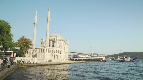 Istanbul, Turkey - September 17, 2021: Awesome view of Ortakoy Mosque and the Bosporus in Istanbul, Turkey. The Bosphorus Bridge (the 15 July Martyrs Bridge) is visible in background.
