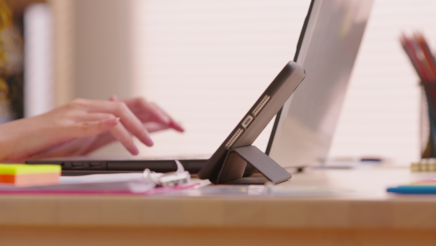 Close up female professional  point out the tablet screen and drawing online business at screen. Digital pen was touching and drawing on digital pad. Working table has digital devices for working.