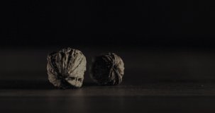 Nuts filmed in slow motion with a dark mood on a wooden background.