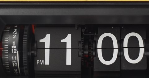 Retro Flip Clock Showing at 11:00 p.m.Spinning Timelapse 2 hours on black background.