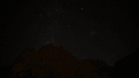 Night sky stars, Milky way galaxy moving over the mountain ridge time-lapse. Moving and rotating stars. Video made in southern hemisphere.
