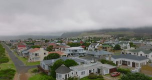 Landing footage of residential development in town. Family houses with gardens on cloudy day.