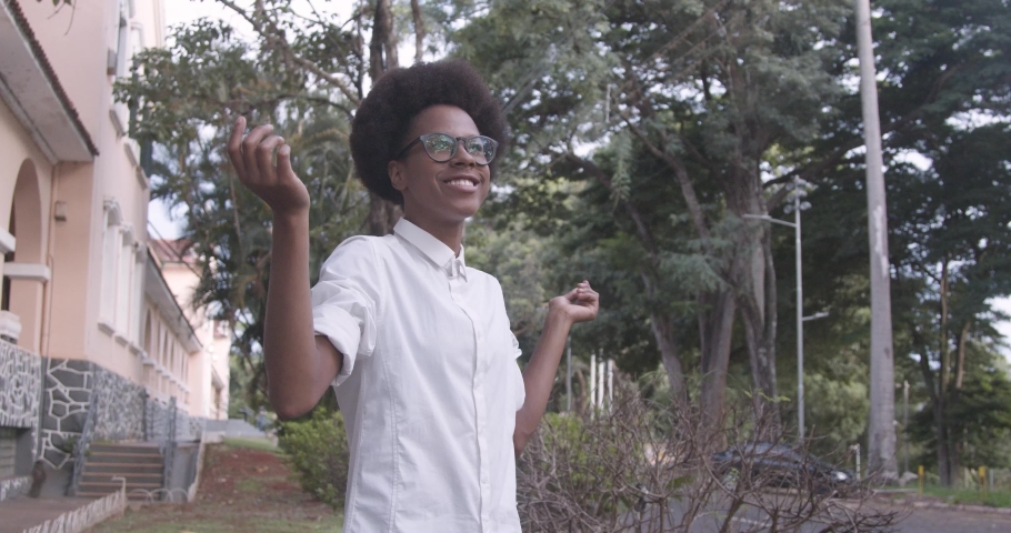 Young african american woman twirling with open arms at university, University of São Paulo. Ribeirao Preto - Brazil. Cinematic 4k