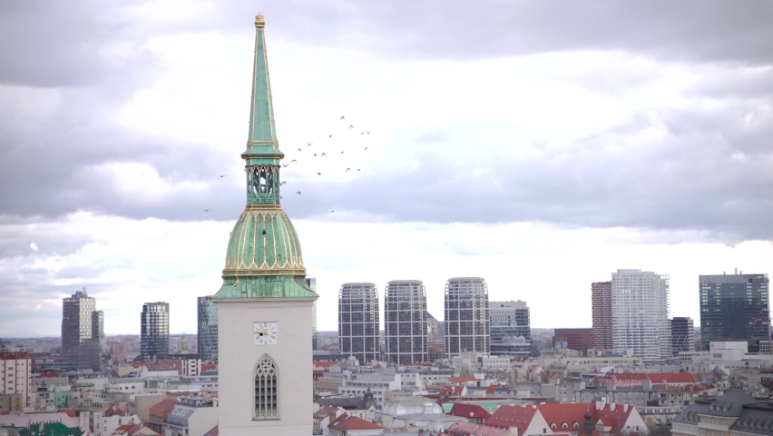 Birds flying around St. Martin Cathedral steeple above Bratislava city.
