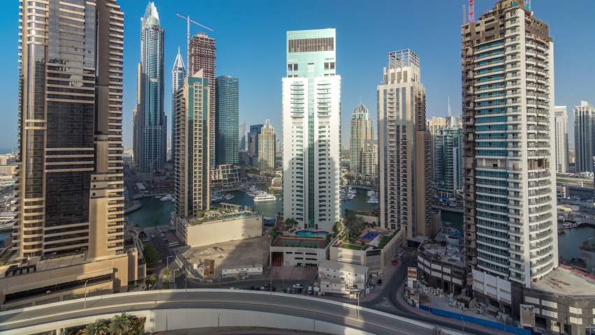 Amazing colorful dubai marina skyline during sunset timelapse. Great perspective of shadows on multiple tallest skyscrapers. Sunlight over buildings. United Arab Emirates.