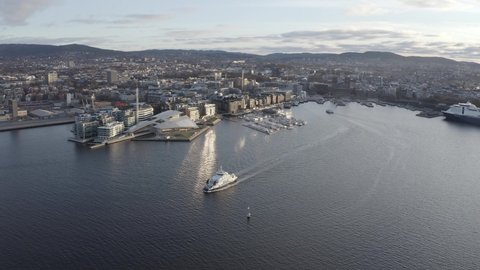 The Oslo fjord and harbor around aker brygge during sunrise. See the spectacular Oslo landmark with 4k drone video. Oslo city skyline visible in the background. 