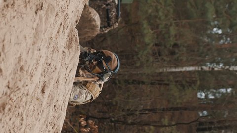 Vertical shot Focused soldier at ground level stance aiming using target scoop . High quality 4k footage