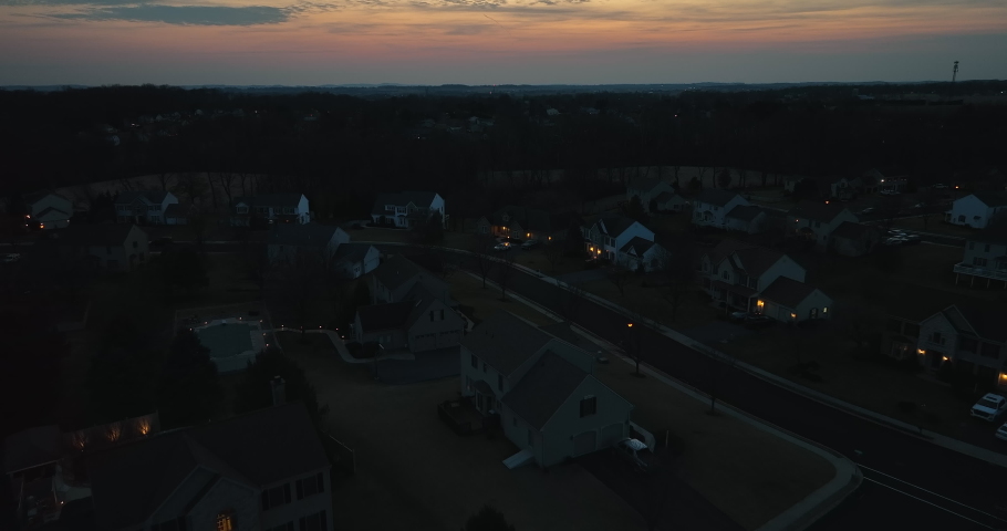 Suburban homes at night. Twilight evening night shot in darkness. Twinkle of lights on homes in suburban American neighborhood. Royalty-Free Stock Footage #1088483403