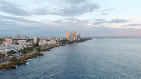 Malecon waterfront coast at dusk, Santo Domingo in Dominican Republic. Aerial forward