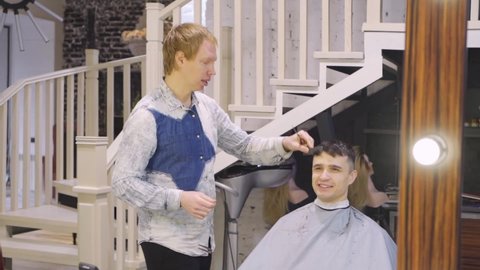 barbershop. the hairdresser makes a haircut for a brunette man with a scissors. professional services. beauty salon for men. cosmetics and products for scalp and hair care.