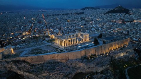 Acropolis in Athens at night, flying above illuminated Parthenon in Athens in the evening, night view of downtown Athens, international landmark in Greece. High quality 4k footage