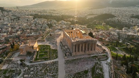 Parthenon in Athens aerial view at sunrise, flying around ancient Greek Acropolis, symbol of greek civilisation, city of Athens skyline, with famous tourist landmark. High quality 4k footage