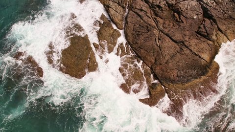 Aerial view top down of big waves crashing on rocks in dark blue ocean. Beautiful sea waves water texture. Drone view high quality 4k shot.Bird's eye view Travel and nature background concept 59.94fps