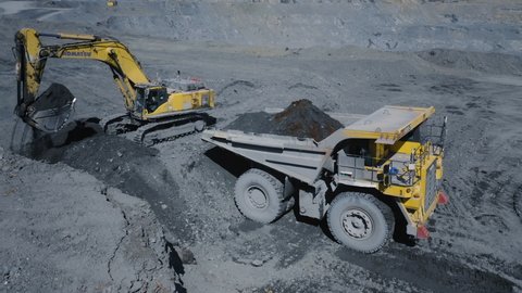 August 16, 2021, Kupol, Russia. A Komatsu PC750 excavator loads ore into a Komatsu HD1500 dump truck. The action takes place in an open pit. Aerial view.