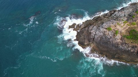 Aerial view top down of big waves crashing on rocks in dark blue ocean. Beautiful sea waves water texture. Drone view high quality 4k shot.Bird's eye view Travel and nature background concept 25fps