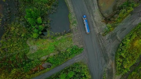 Aerial View On Blue Heavy Transport Vehicle Driving Near Beautiful Landscape. Heavy Transport Truck Vehicle In Wildlife Environment. Industrial Heavy Vehicle Transports Natural Mineral Product
