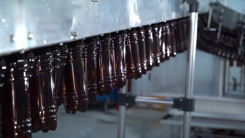 Light Beer Bottling Plant Belt At Beer Factory. Empty plastic bottles are moving in the