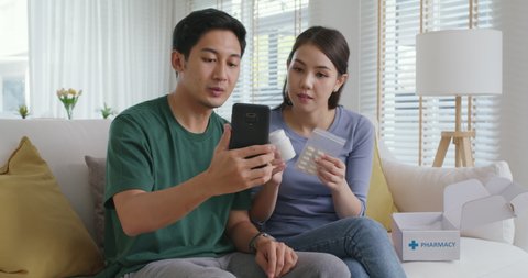 Young married asia people prepare pregnant plan checkup preconception consult at home sofa. Clinic app illness screen on online advice doctor remote exam telemedicine video call talk on tablet phone.