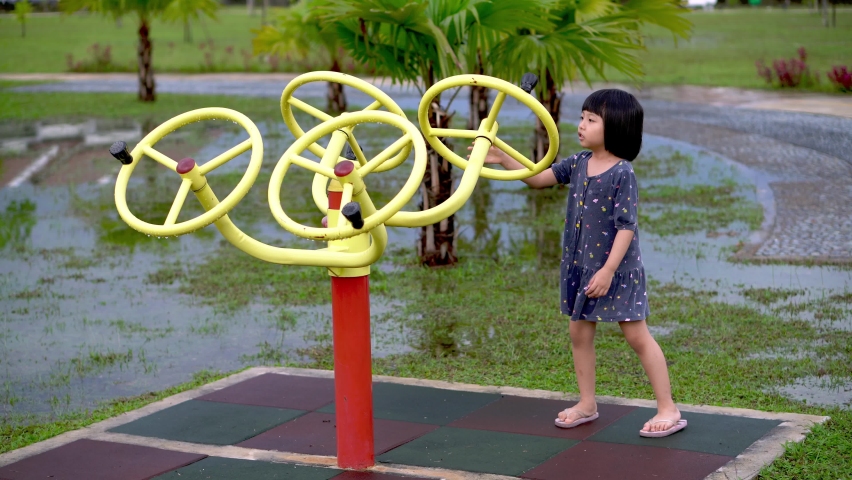 Chinese little girl play fitness equipment at playground