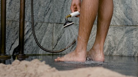 4K 50fps, Close-up of a pair of feet, washing feet, using a shower to clean water, and rubbing the other foot to make it more clean.