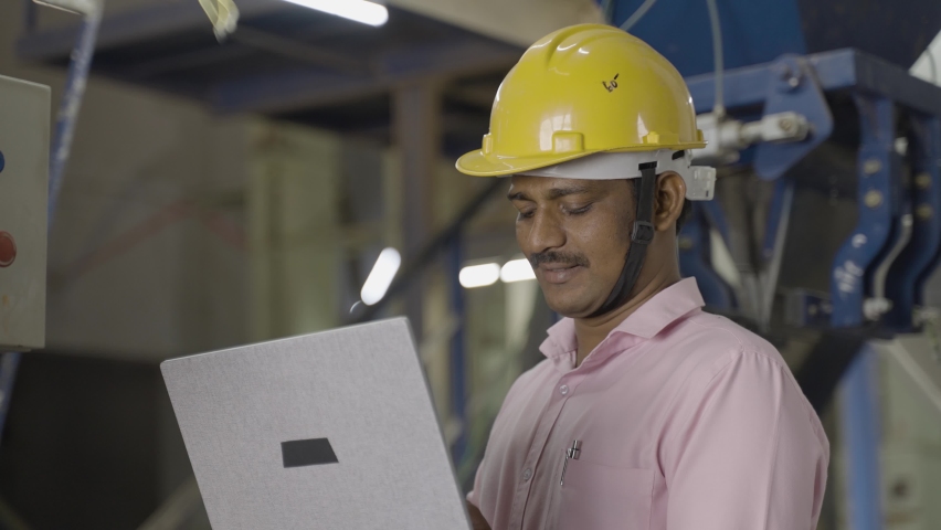 handheld shot of engineer in uniform busy working on laptop at machinery in factory - concept of technology, skilled or professional labour and development. Royalty-Free Stock Footage #1088498621