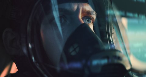 Close up shot of determined military armed forces soldier or pilot wearing protective oxygen visor mask inside cockpit of fighter jet airplane during aviation warfare or flight training routine.