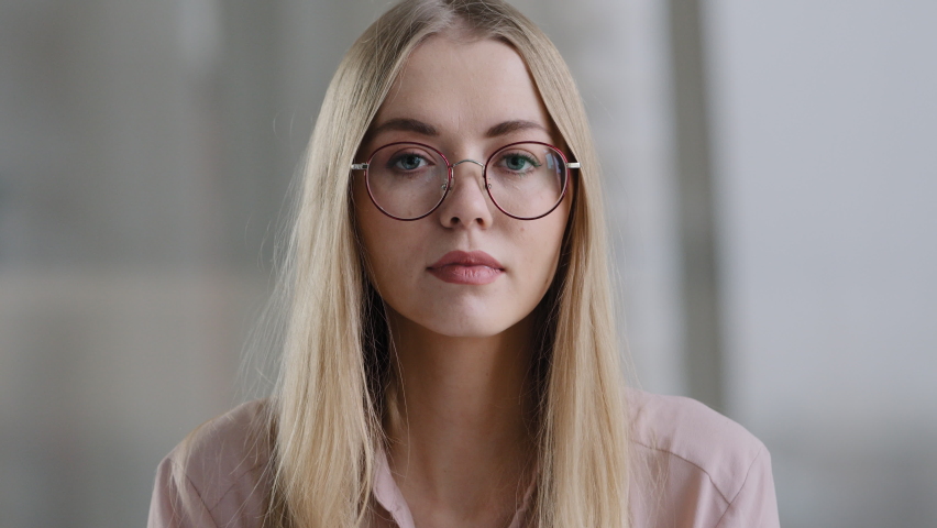 Close-up portrait female face millennial 30s girl blonde woman with poor eyesight takes off glasses looking at camera wide open eyes and mouth shock surprise stun amazed unexpected news says that | Shutterstock HD Video #1088503151