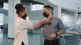 Indian businessman and african businesswoman wear medical face masks greeting with elbow bump in office coronavirus rules two partners colleagues avoid touch protection covid 19 spreading prevention - Powered by Shutterstock - Get 15% off with code: PIKWIZARD15