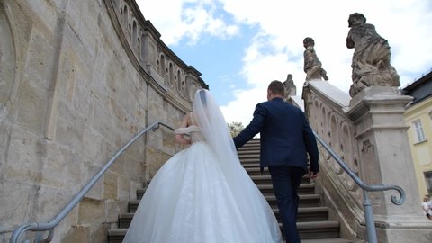 The bride and groom climb the stairs