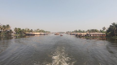 View from sailing boat of houseboats at Alappuzha or Alleppey, India. Backward shot