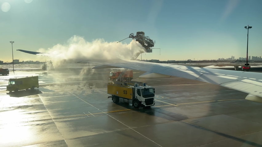 Anti-Icing Fluids Sprayed on an Airplane Wing to Remove Frost and Snow - Fixed Shot Royalty-Free Stock Footage #1088504573