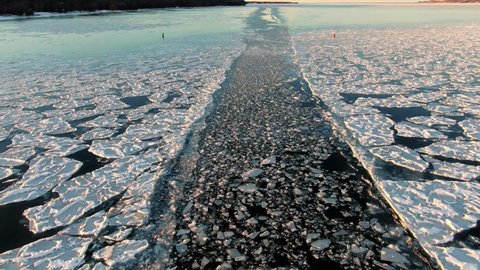 A boat's path through a frozen lake in Sturgeon Bay, Wisconsin during and afternoon wintertime day in January